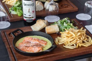 Salmon filet in creamy entrecôte sauce with fries, salad and baguette at rooftop restaurant Larnaca