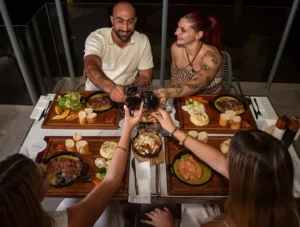Friends enjoying steak and wine at Memories L’Entrecôte’s Restaurant Rooftop in Larnaca